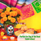 coco day of the dead papel picado party banner with marigolds in vase on table