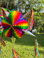 Colorful rainbow pinata with tassels on a grassy background